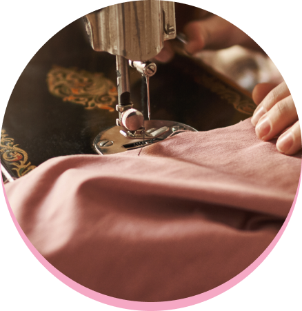 Máquina de coser cosiendo una tela rosa